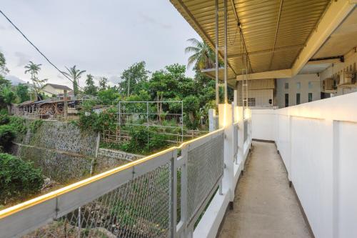 a balcony of a building with a fence and trees at RedDoorz Syariah near Taman Air Mancur Bogor in Bogor
