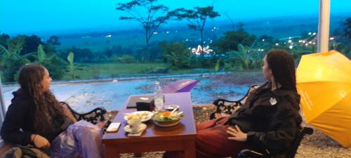 two women sitting at a table with an umbrella at Driver tour Borobudur, Rice Terace & hiden scared waterfall in Blaburan