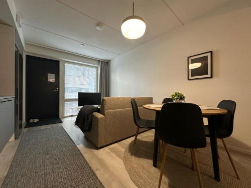 a living room with a table and a couch at Pramea Apartments Aallonharja 4 in Jyväskylä