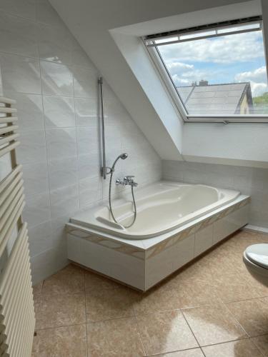 a bathroom with a bath tub and a window at Eastside-Apartment WHG 01 in Senftenberg