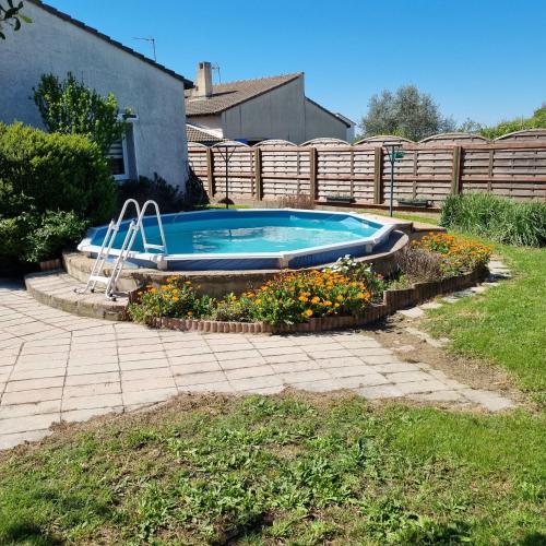 une piscine dans une cour avec des fleurs autour dans l'établissement Vacances entre mer et montagne, à Alès