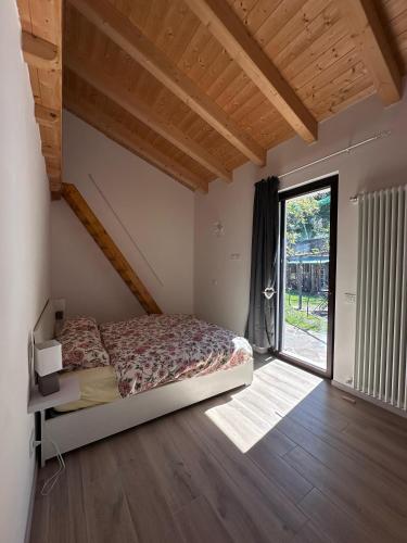 a bedroom with a bed and a large window at Appartamento Riflessi D'Acqua in Navene