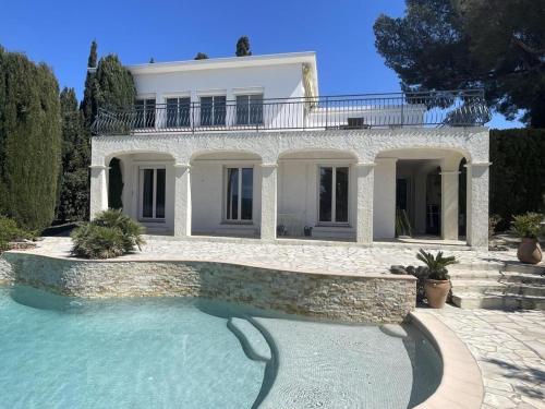une grande maison blanche avec une piscine devant dans l'établissement Villa 3 étoiles de 120m2 - vue mer - clim - mer à 600m, à Roquebrune-sur Argens