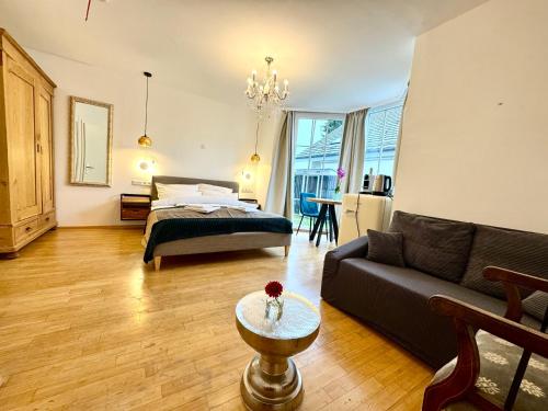 a living room with a bed and a couch at VILLA ORCHARD Frankfurt - Trade Fair Airport in Kriftel