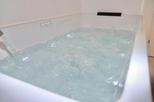 a tub filled with green water in a bathroom at Ringo Suites in Grumo Appula