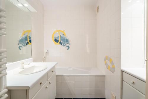 une salle de bain blanche avec un lavabo et une baignoire dans l'établissement Vue marine par Dodo à Cassis, à Cassis