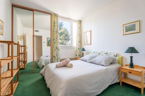 une chambre avec un grand lit blanc et une fenêtre dans l'établissement Vue marine par Dodo à Cassis, à Cassis