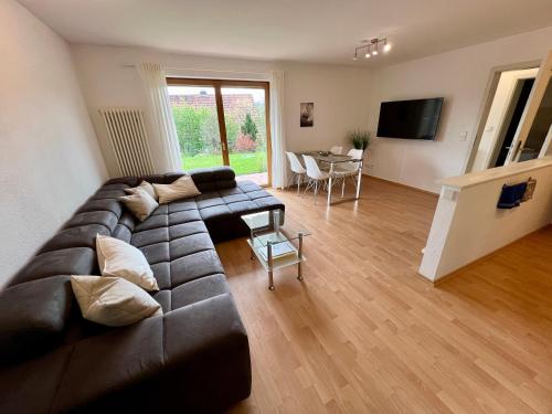 a living room with a brown couch and a table at Gemütliche Ferienwohnung im Herzen des Schwarzwaldes in Niedereschach