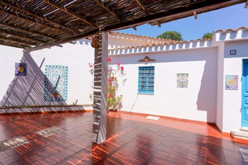 a patio with a ladder in front of a white building at Agriturismo Costa del Sud in Teulada