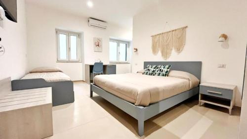 a bedroom with a bed and a desk in it at Flamingo Suites in Marina di Camerota