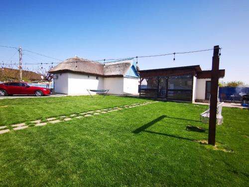 a grassy yard with a building and a sign in the yard at Casa lui Matei Murighiol in Murighiol