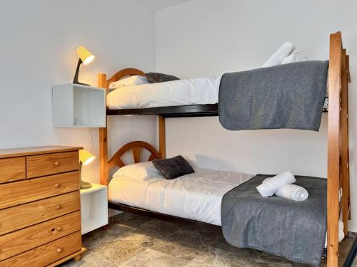 a bedroom with two bunk beds and a dresser at ChicFlat Río Ciudad Real Dúplex en el centro in Ciudad Real