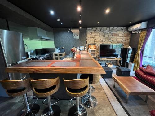 a large kitchen with a long wooden table and chairs at ゲストハウス熱海西山ガーデン in Atami
