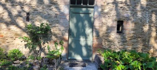 a door on the side of a stone building at LA CHAMBRE DU CANTOU in Lautrec