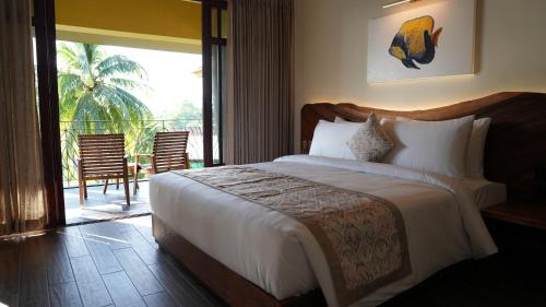 ein Schlafzimmer mit großem Bett und Balkon in der Unterkunft Waterwoods Boutique Resort & Villas Havelock in Havelock Island