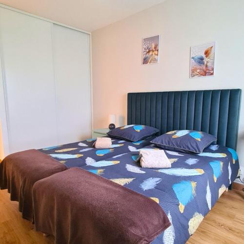 - une chambre avec 2 lits et une tête de lit bleue dans l'établissement L'Escapade Enchantée, à Leyment