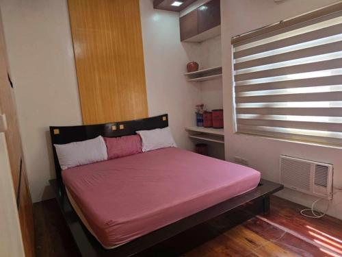 a small bed in a room with a window at Queen Isabel Private Villa and Events Place in Tagaytay