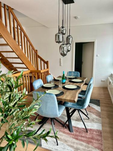 a dining room with a wooden table and blue chairs at Apartment über 3-Etagen genau im Zentrum! in Neumünster