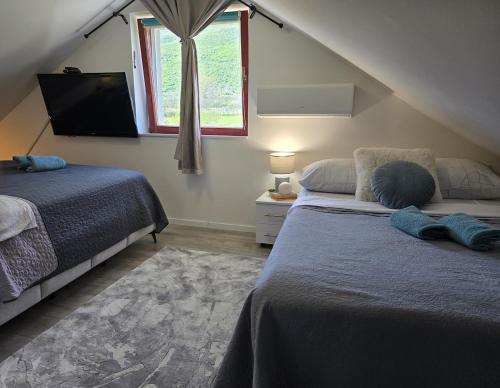 a bedroom with two beds and a window at Grey House with heated pool Kričke Drniš in Kričke
