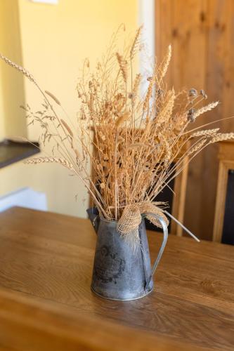 a vase filled with dried grass sitting on a table at Mlýn Kamenice in Klučenice