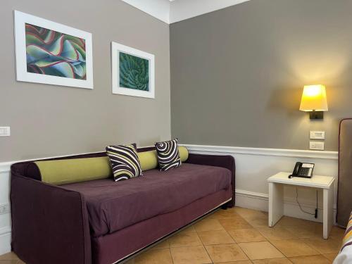 a couch in a living room with two pillows on it at Hotel Della Piccola Marina in Capri