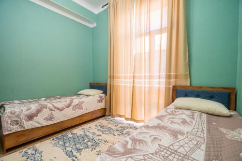 a bedroom with two beds and a window at Коттедж Иссык - Куль in Chon-Sary-Oy