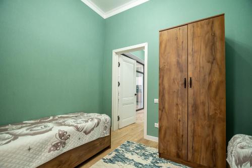 a bedroom with a bed and a wooden cabinet at Коттедж Иссык - Куль in Chon-Sary-Oy