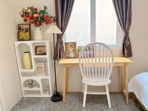 a desk in a bedroom with a chair and a window at Linh Ngọc Châu Hotel in Ho Chi Minh City