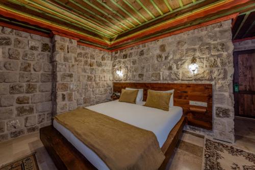 a bedroom with a bed in a stone wall at Latona Stone Palace in Nevsehir