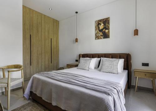a bedroom with a large bed and a chair at D'Oliva, by ZanteWize in Zakynthos Town