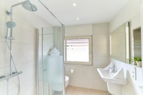 a white bathroom with a sink and a shower at Oberhausen an der Nahe LIEBLINGSORT - Ferienappartements in Oberhausen