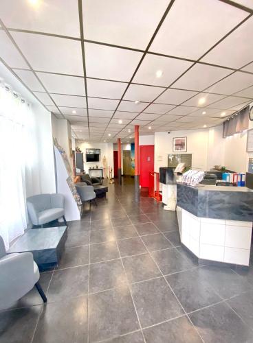 an office lobby with a waiting room with chairs and tables at Hipotel Belgrand Edith Piaf in Paris