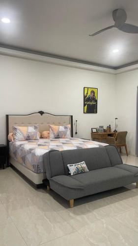 a bedroom with a large bed and a couch at Rumah Malika in Munggu
