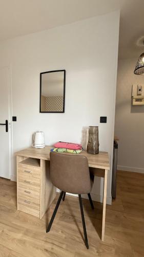 a wooden desk with a chair and a mirror at Madeleine - Studio Charmant in Orléans