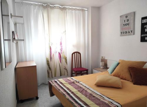 a bedroom with a bed and a chair in it at Terrace & Sea Views in Cullera in Faro de Cullera