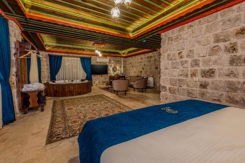 a bedroom with a bed and a stone wall at Latona Stone Palace in Nevsehir