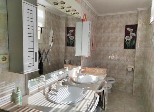 a bathroom with a sink and a toilet and a mirror at Terrace & Sea Views in Cullera in Faro de Cullera