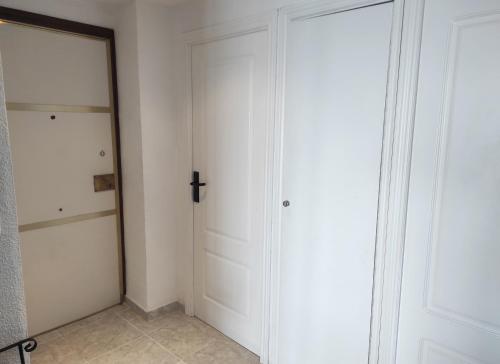 a white closet with a cross on the door at Terrace & Sea Views in Cullera in Faro de Cullera
