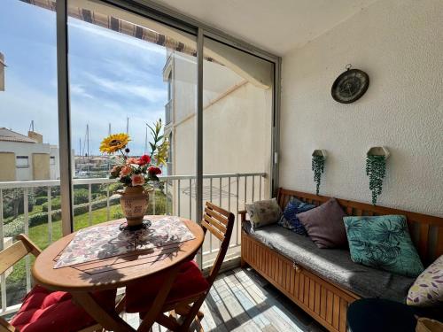 - un balcon avec une table et un canapé dans l'établissement Appartement - Cap d'Agde, au Cap d'Agde