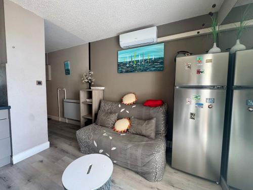 - un salon avec une chaise et un réfrigérateur dans l'établissement Appartement - Cap d'Agde, au Cap d'Agde