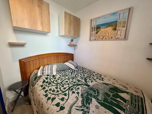 - une chambre avec un lit et une photo de la plage dans l'établissement Appartement - Cap d'Agde, au Cap d'Agde