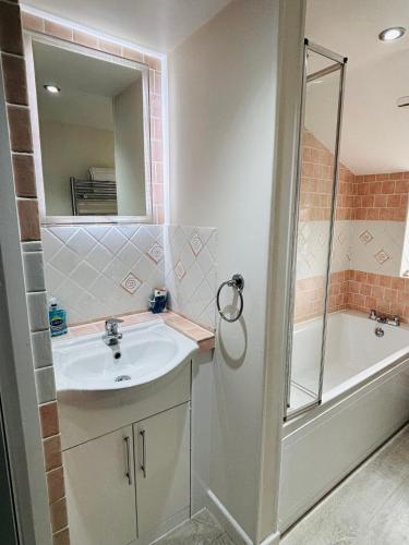 a bathroom with a sink and a shower and a tub at Foundry Cottage in Portland