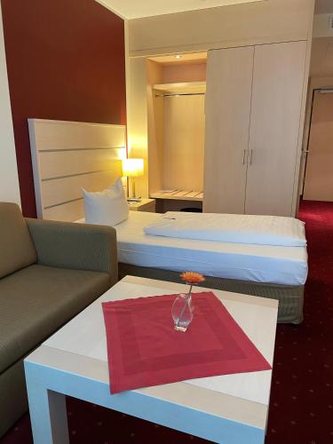 a hotel room with two beds and a table with a red napkin at Aspire AcarA Oldenburg, Trademark Collection by Wyndham in Oldenburg