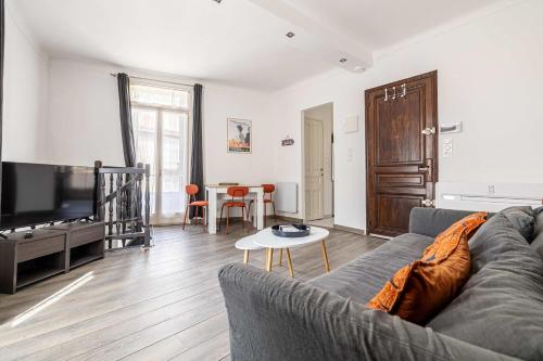 un salon avec un canapé et une télévision à écran plat dans l'établissement LA MAISON DU SUQUET duplex avec terrasse en plein centre, à Cannes