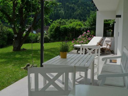 a white table and chairs on a patio with a yard at Ferienwohnung Peterberg 22, 45qm in Kirchzarten