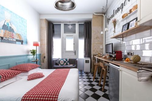 Ce petit appartement comprend un lit et une cuisine. dans l'établissement Artisan Lofts Paris close Eiffel Tower, à Paris