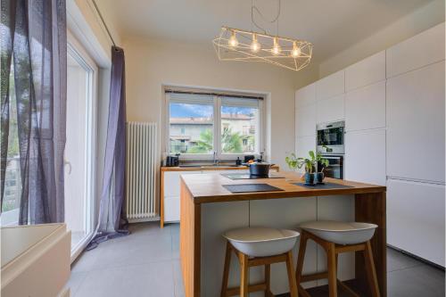 a kitchen with a counter and two stools at a island at Suono del Lago 100m from Lake - Happy Rentals in Meina