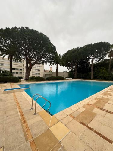 une grande piscine bleue avec des arbres en arrière-plan dans l'établissement Studio with swimming pool, à Vallauris