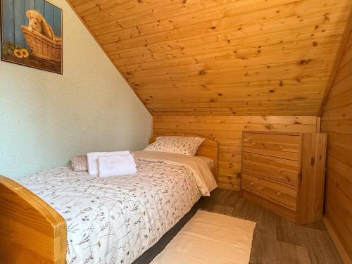 a small bedroom with a bed in a cabin at Počitniška hiša z dvema spalnicama Sauna & Jacuzzi in Gorica pri Slivnici