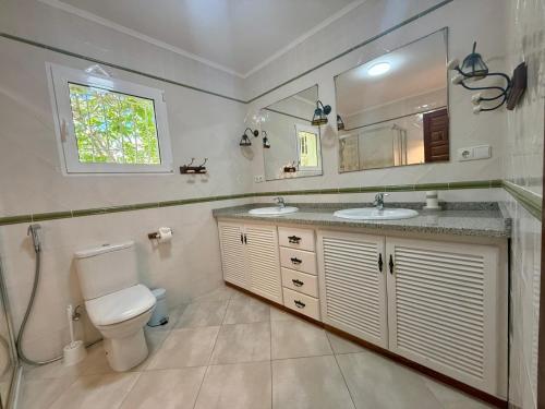 a bathroom with a toilet and a sink and a mirror at AT060 Villa Ortenbach in Ifach